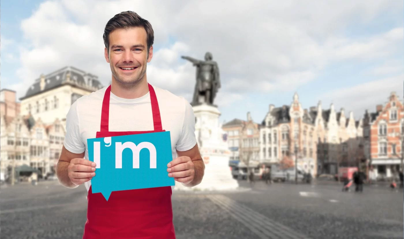 winkeleigenaar staat in Gent met IntelliGent Mobiel logo in zijn handen